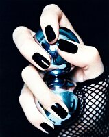 Close-up of woman wearing black nail polish, holding two Chi Gong balls