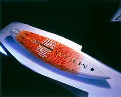 Close-up of a colourful surfboard against black background