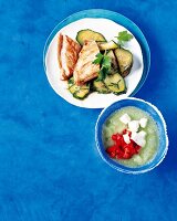 Putenbrust mit Kräuter-Zucchini, daneben Gurkensuppe mit Feta