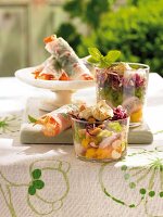 Chicken layer salad in glass bowl and Thai vegetable rolls on side