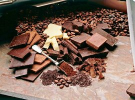 Different varieties of chocolate, chocolate chips and chocolate beans on wood