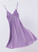 Purple summer dress with spaghetti straps in hanger on white background