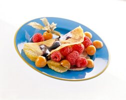 Crepe with fruits and raspberries on plate
