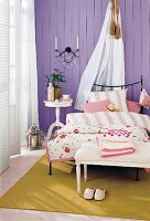 Blick auf Schlafzimmerbett vor lila Wand, Himmelbett mit Organza