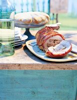 Italian roast pork roll with bacon crust on plate