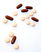 Close-up of oval and round pills on white background