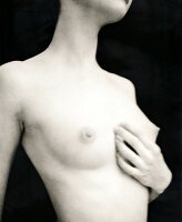 Close-up of nude woman touching her chest