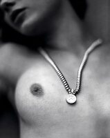 Brillant-Anhänger an nackter Brust s/w Foto