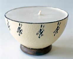Close-up of candle in half ostrich egg shell with ethnic print