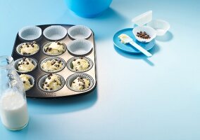 Raw muffins dough in muffin tray with chocolate chips - preparation of muffin