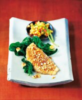 Red Snapper with nuts, spinach and papaya salsa on plate