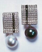 Close-up of two black and white diamond earrings with Tahitian pearl