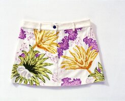 Close-up of white mini skirt with floral pattern on white background