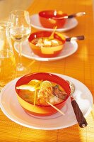 Asiasuppe mit Garnelen u. Kokoscurry serviert in Orange