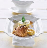 Roasted rabbit with lemon, garlic, white wine and vanilla in white serving plate