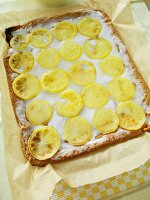 Lemon cake batter with olive oil and lemon slices on butter paper