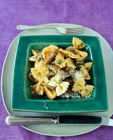 Farfalle pasta marinated with artichokes and beef on square shape plate