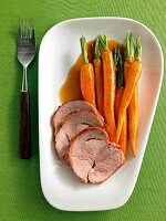 Turkey thigh with balsamic carrots in white serving dish