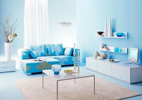 Wohnzimmer in hellblau und türkis gehalten, Frau entspannt sich, Sofa