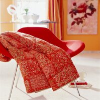 Rotes Plaid mit orientalischem Muster auf einem Stuhl
