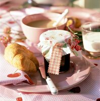 Frühstück mit Erdbeermarmelade, Croissant, Milchkaffee