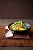Couscous - Salat in einer braunen Schale neben einem Holzlöffel