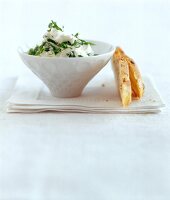 White cream with basil leaves and bread slices on tissue