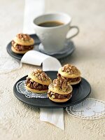 Biscuit cookie with praline filling and teacup on black plate