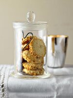 Glass jar with stack of almond cookies on table