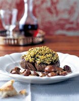 Beef fillet steak with herb crust, nuts and mushrooms on plate