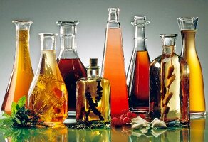 Close-up of eight different types of vinegar in glass bottles