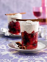 Berries punch with poppy cream in glass on plate