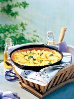 French apple tart in baking tray on basket