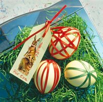 Close-up of three Easter eggs decorated with satin ribbons