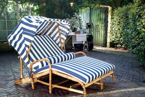 Rattan lounge chair in blue and white colour with sliding cover on terrace garden