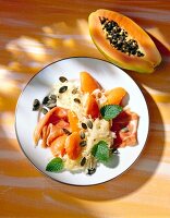 Sauerkrautsalat mit Papaya und Parmaschinken auf Teller