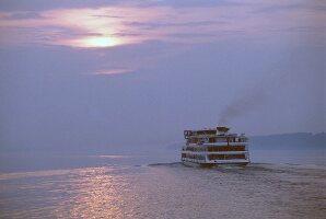 Kreuzfahrtschiff fährt auf der Wolga dem Sonnenuntergang entgegen