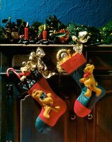 Zwei Nikolausstiefel mit Teddybären hängen von einem Bord