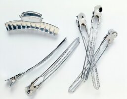 Various hair clips and hair pins made of metal on white background