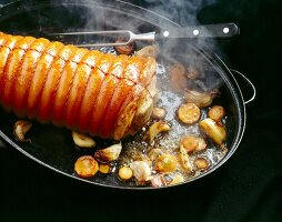 Schweinerollbraten mit Sauerkraut wird in Pfanne mit Zwiebeln gebraten