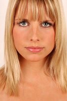Portrait of beautiful green eyed blonde woman with bangs, close-up