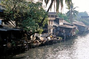 Blick auf Häuser auf Pfählen an einem Fluss in Bankok, Thailand