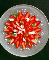 Strawberry carpaccio with parmesan cheese, chocolate and lemon balm, overhead view