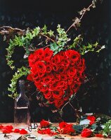Gesteck aus roten Rosen in Form eines Herzens.