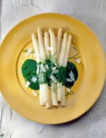 Asparagus with spinach and sorrel sauce on yellow dish