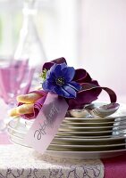 Table napkin wrapped with asparagus and spoon on stack of plate