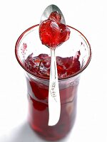Glass of redcurrant jelly with spoon on it