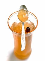 Glass of apple and pear jelly with spoon on it