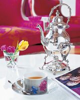 Orientalisches Teegedeck mit drei Blumen im Wasserglas im Wohnzimmer