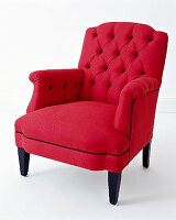 Roter Sessel mit dunkel eingefassten Nähten und Knöpfen